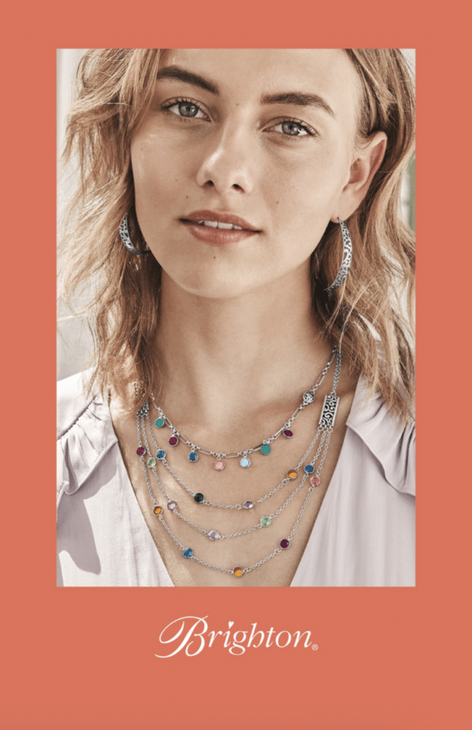 A picture of a blond woman in white shirt with a beautiful necklace. 