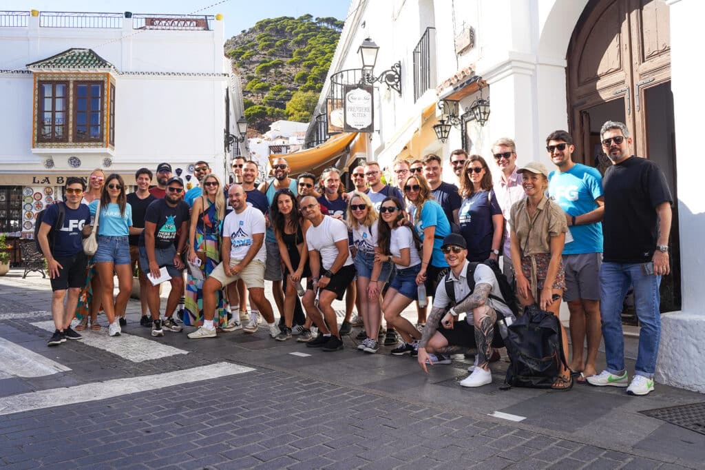 A large group photo of Publitas employees smiling while visiting Mijas in Spain. Sunny weather.