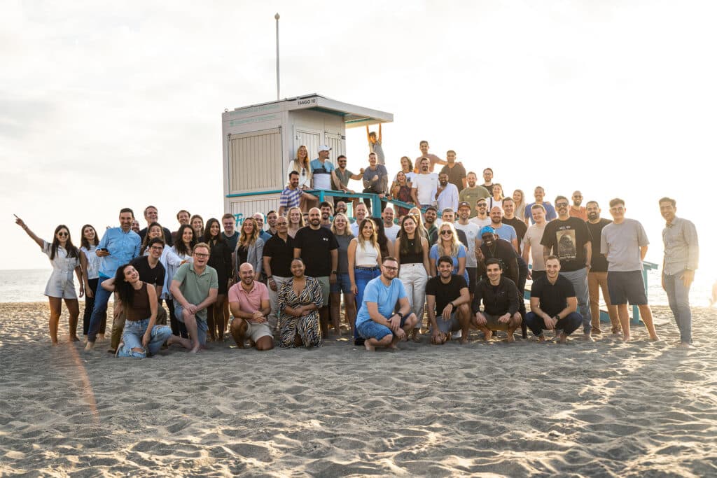 Photo de groupe de l'équipe Publitas sur la plage. À propos de nous 2024.