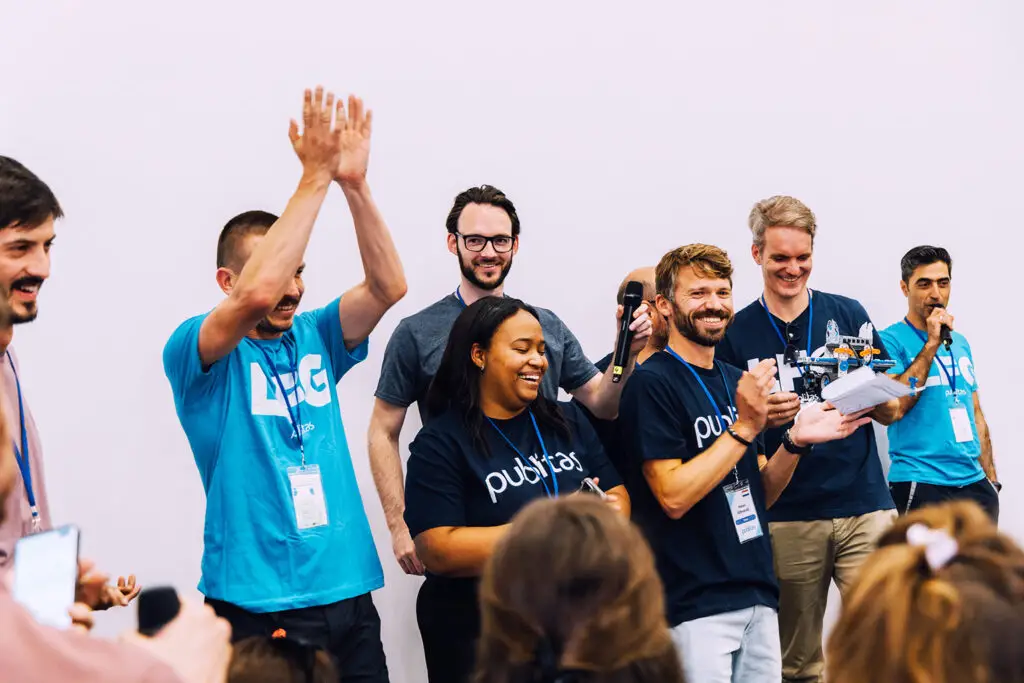 Group of Publitas employees cheering during a team activity.