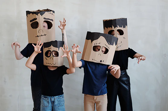 Halloween Trends Every Retailer Should Watch In 2025 2 A group of people wearing paper bags on their heads with drawn on black marker