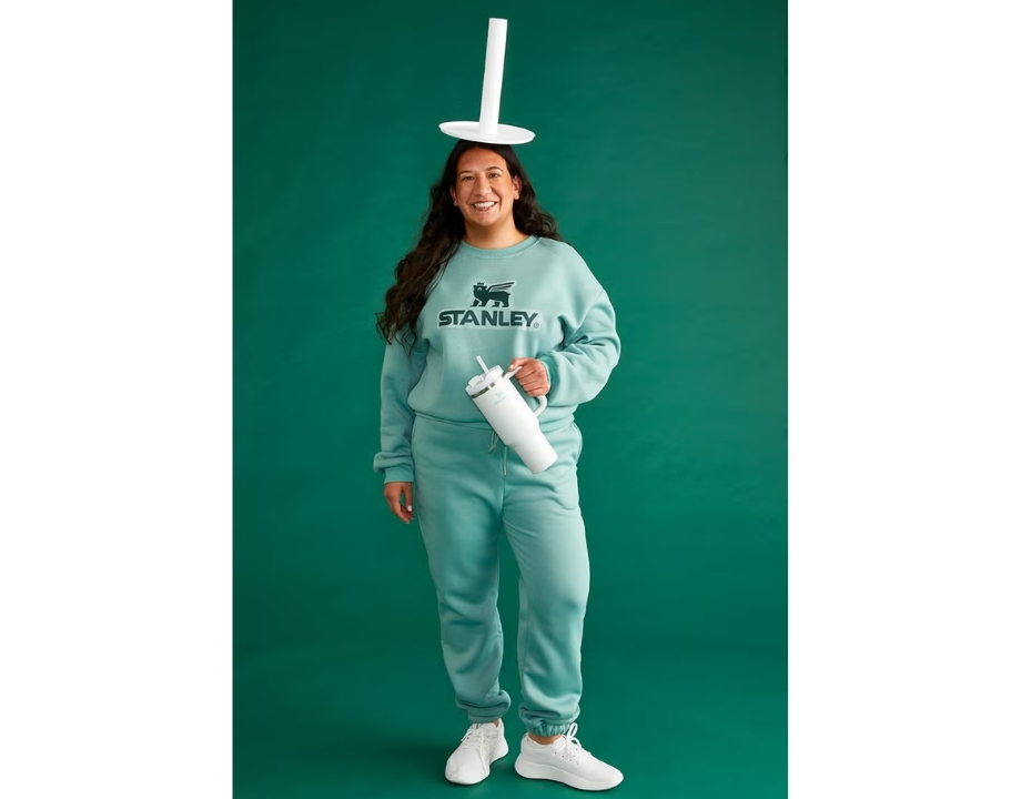 Halloween Trends Every Retailer Should Watch In 2025 1 A women standing against a green background with a white object on her head and holding a stanley cup