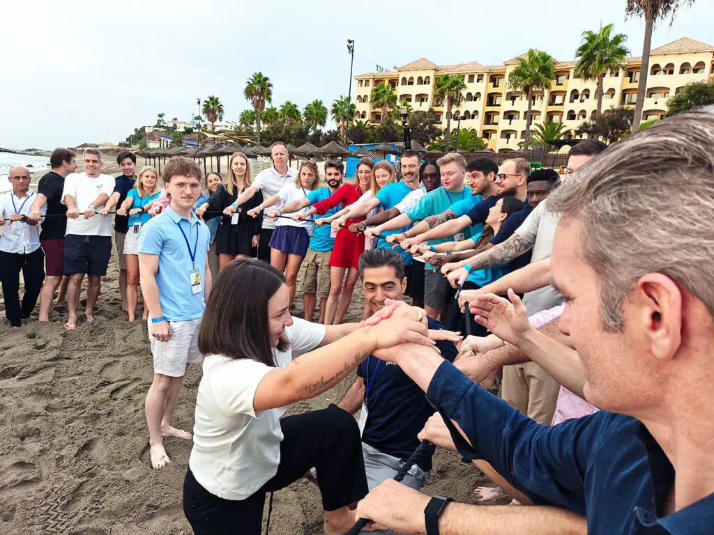 Group of Publitas employees doing a team activity on the beach.
